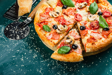 Traditional Italian pizza on a green chalkboard with ingredients. Pizza menu. Space for text. view from above