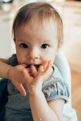Little girl having food on her hands and fingers while eating stock photo