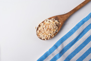 oat flakes in wooden scoop and ripe ears isolated on white background