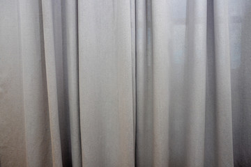 Obraz premium Light gray fabric curtain closed like on a theater show stage, with light in the middle, background, texture.curtain grey color for interior