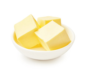 Butter pieces in white bowl isolated on white background. Butter cubes.