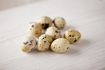 Obraz premium Quail eggs on white wooden table. Selective focus