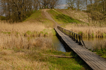 Wooden bridge over a narrow river.