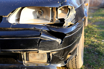 broken wing and headlight on the black car