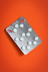 packs of pills opened pills isolated on orange background