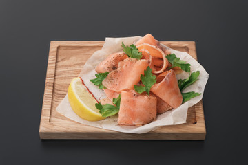 Smoked wild salmon with lemon on wooden background