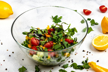 Fitness salad from different fresh greens , tomatoes, peppers, avocados, cucumbers with olive oil and balsamic sauce in the glass bowl. The concept of healthy diet food. Slimming food.