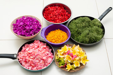 Red, purple, orange, pink, and yellow petals in a pot and bowl