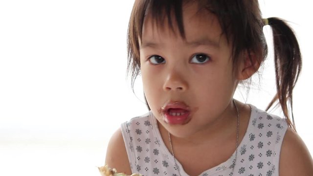 Cute asian child girl enjoying with eating ice cream and sloppy mouth, isolated on white background.
