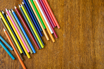 Colored pencils on wood desk. 