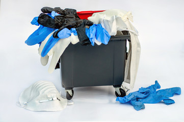 Bunch of used protective mask and medical gloves in the trash can on a white background. Quarantine Completion. World outbreak covid-19. Waste debris crown pollutes the environment. Pollution concept