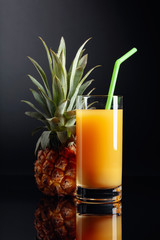 Pineapple and juice on a black  background.