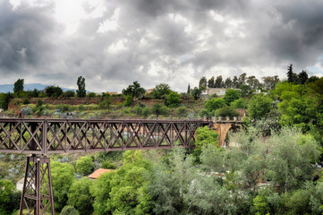puente de metal entre naturaleza en un dia lluvioso con un cielo gris