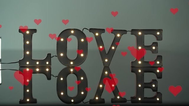 Love light sign with reflection flickering on and off with red floating hearts
