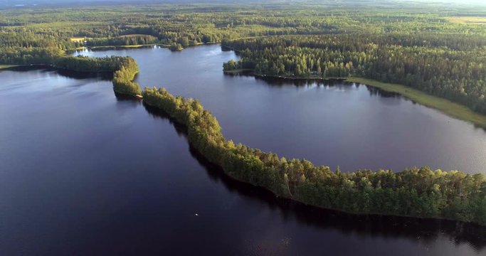 Liesjarvi national park, Aerial, pull back, drone view over a long, narrow Kyynaranharju esker at a lake, during golden hour, in Finland
