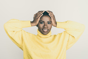 Attractive content woman with hands on head. Portrait of beautiful young African American woman...