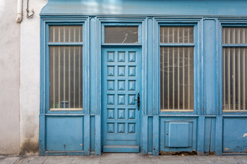 Pretty facade of a rustic building with a bright blue door