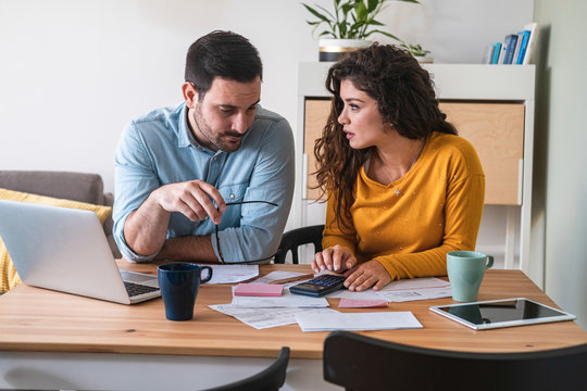 Worried husband and wife manage finances at home stock photo