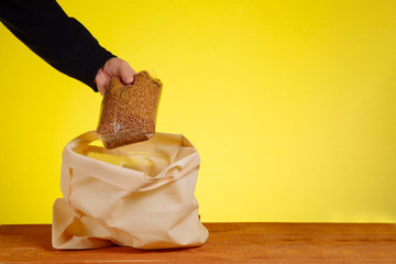 A volunteer puts buckwheat in a cotton bag. Friendly packaging, cotton bag. Biodegradable packaging. Food concept