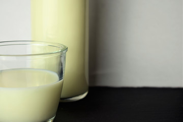 Close up, glass of milk, next to it part of a bottle