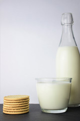 Close-up a glass of milk as main shot along with cookies on slate table