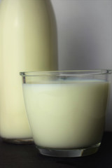Close up, glass of milk, next to it part of a bottle
