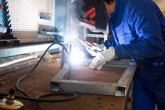 Worker welding metals on the job