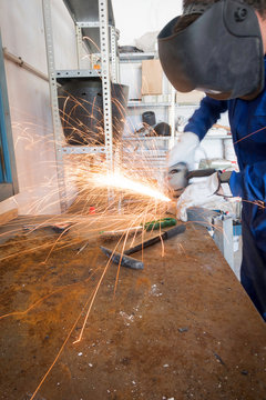 Worker welding metals on the job