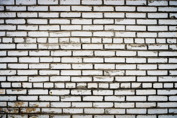 Background of an old, dirty, white brick wall with peeling plaster, painted walls, texture
