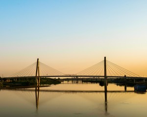 Fototapeta na wymiar Suspension Bridge Over River Against Clear Sky