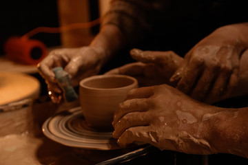 Fototapeta na wymiar Lovers on a date sculpts jug. Potter's hands