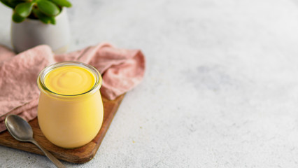 Obraz na płótnie Canvas Yellow mango lassi on gray background. Indian mango yogurt drink with copy space left.