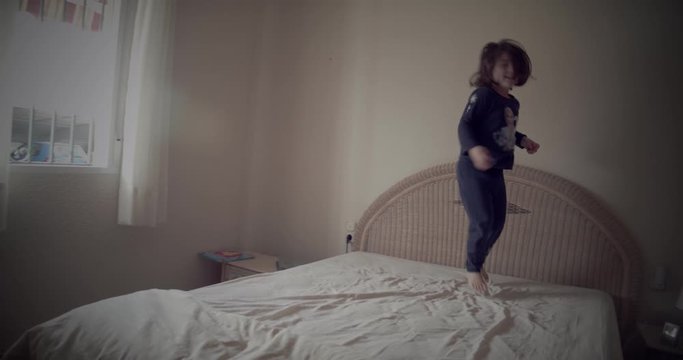 Ni&ntilde;a soriente saltando sobre la cama