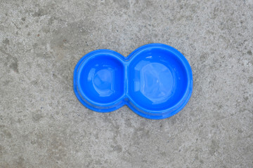 One double plastic pet bowl in blue. Empty bowl on concrete background. View from above.