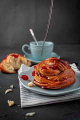 Bun in syrup with a Cup of coffee