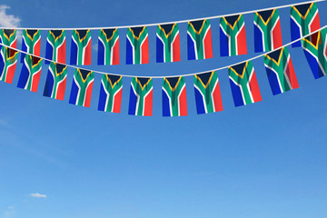 South Africa flag festive bunting hanging against a blue sky. 3D Render