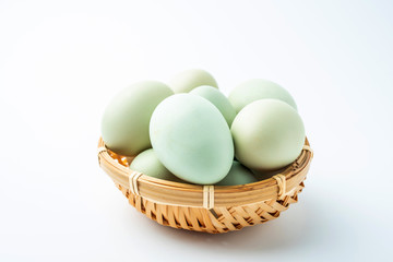 Black eggs in green shell on white background