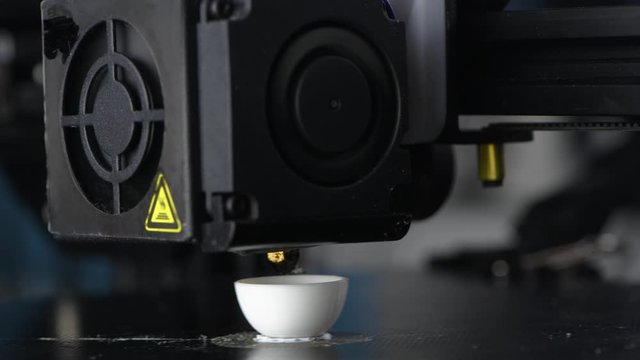 4K The 3D printer prints white plastic model of egg. modern technology.