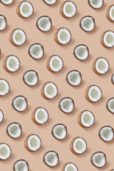 Vertical pattern from ripe tropical coconut's halves on a beige background.