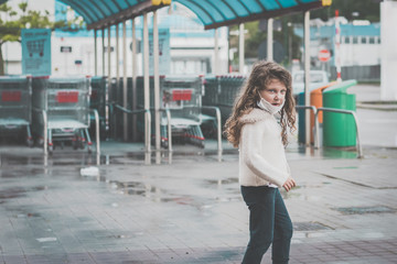 little girl wearing surgical mask near  a supermarket in italy