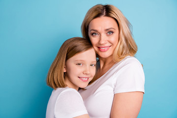 Cloeup profile photo of two people beautiful mommy lady small little daughter blonds hugging good mood best friends wear casual white s-shirts isolated blue color background