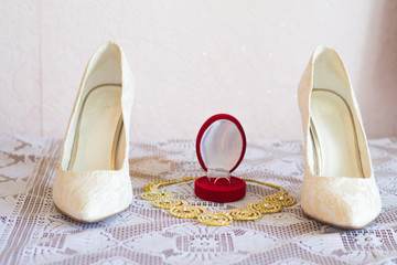 Wedding shoes, gold necklace of the bride, wedding rings