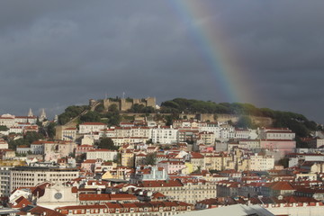 Obraz premium Rainbow over Lisbon city stormy weather dark sky