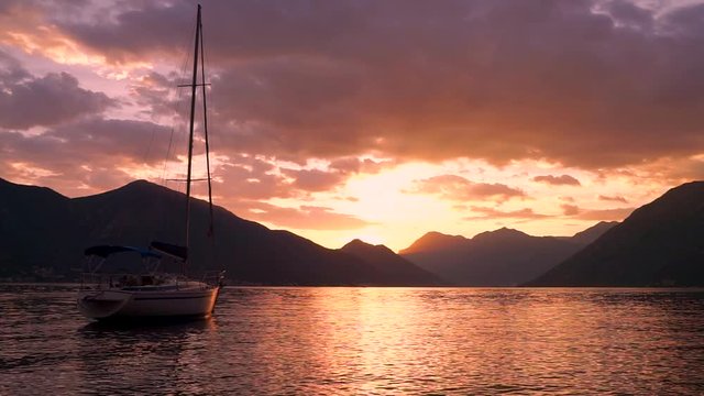 Beautiful sunset with yacht on Beka-Kotor bay near Dobrota village, Montenegro.