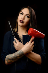 Girl make-up artist with tatoo and makeup accessories on black background. Halo ring lamp