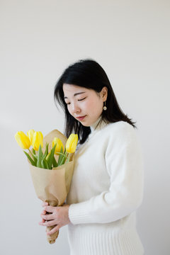 Beautiful young asian woman holding a bouquet of flower