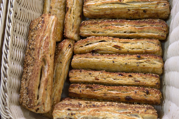 puff pastry bread with flax seeds in a basket on the counter of the bakery department