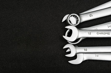 Group chrome plated wrench. Isolated on a black relief background.