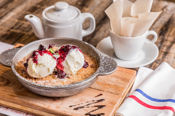 ice cream with red berries with cup of tea