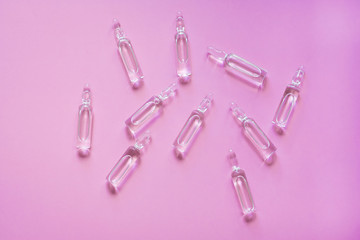 Vaccine for COVID-19. Ampoules with medicine for coronavirus on a pink background. Development and use of a cure for a new virus